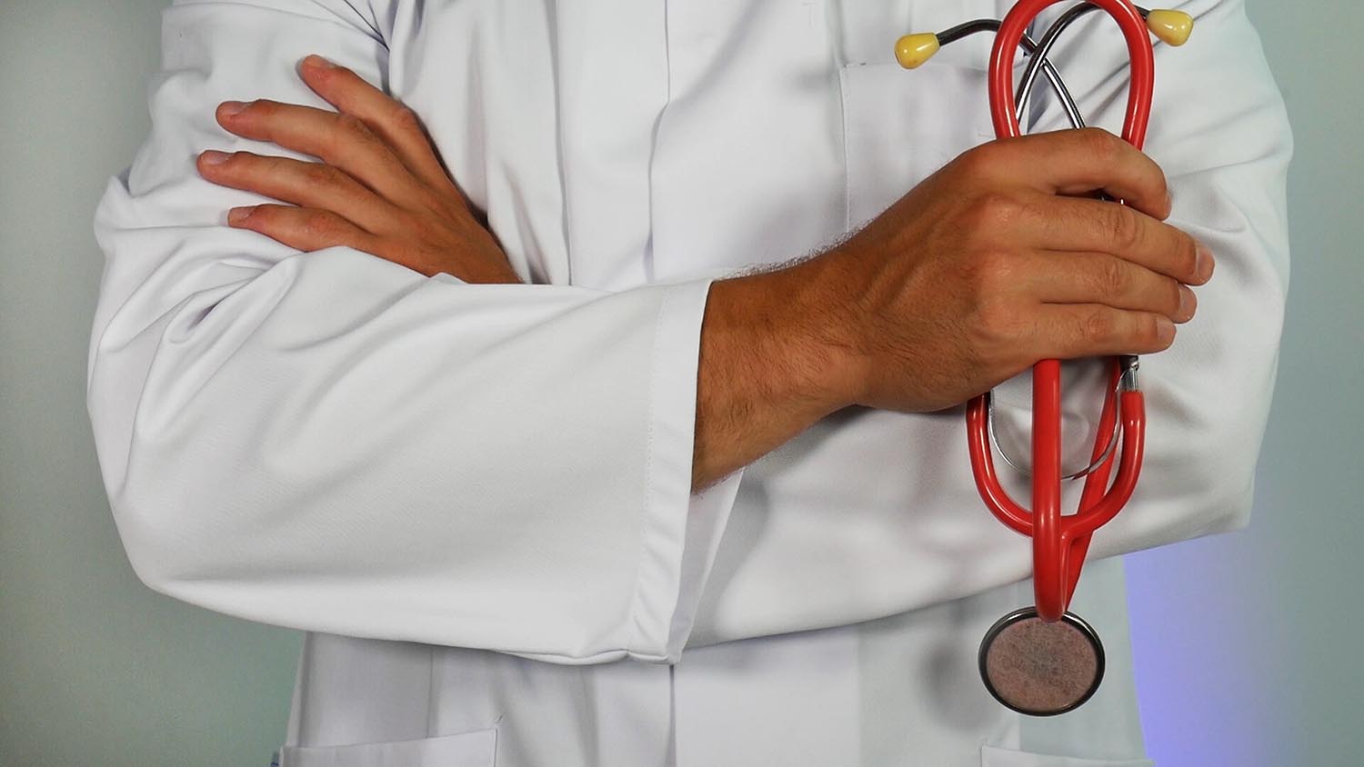 physician crossing arms with red stethoscope malpractice insurance
