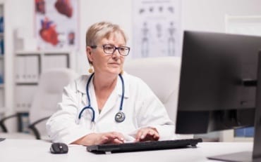 female doctor reviewing unrated medical malpractice insurance carrier on desktop