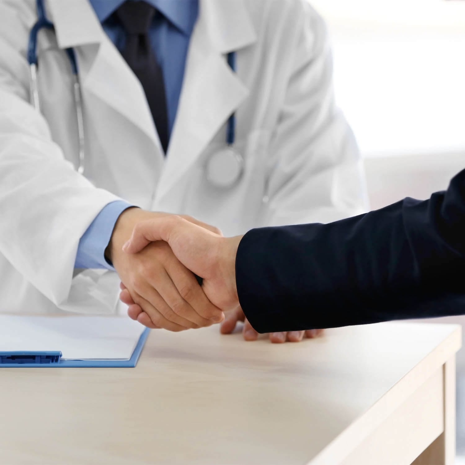 doctor shaking hands with insurance broker in medical clinic