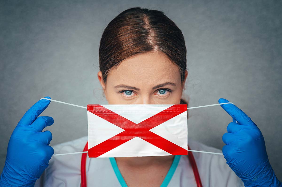 Doctor holding Alabama state flag mask over face malpractice insurance