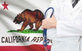 A California Physician With Medical Liability Coverage Standing In Front Of The California State Flag Holding A Stethoscope