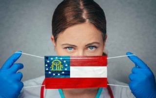 A Female OB/Gyn With A Medical Malpractice Insurance Policy Covering Her Face With A Georgia State Flag Mask