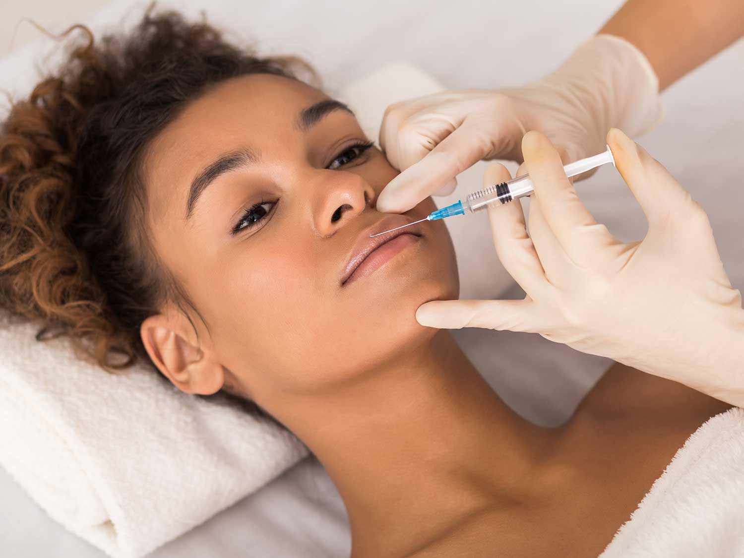 A Patient Receiving A Lip Injection At A Medical Spa With Specialized Malpractice Insurance