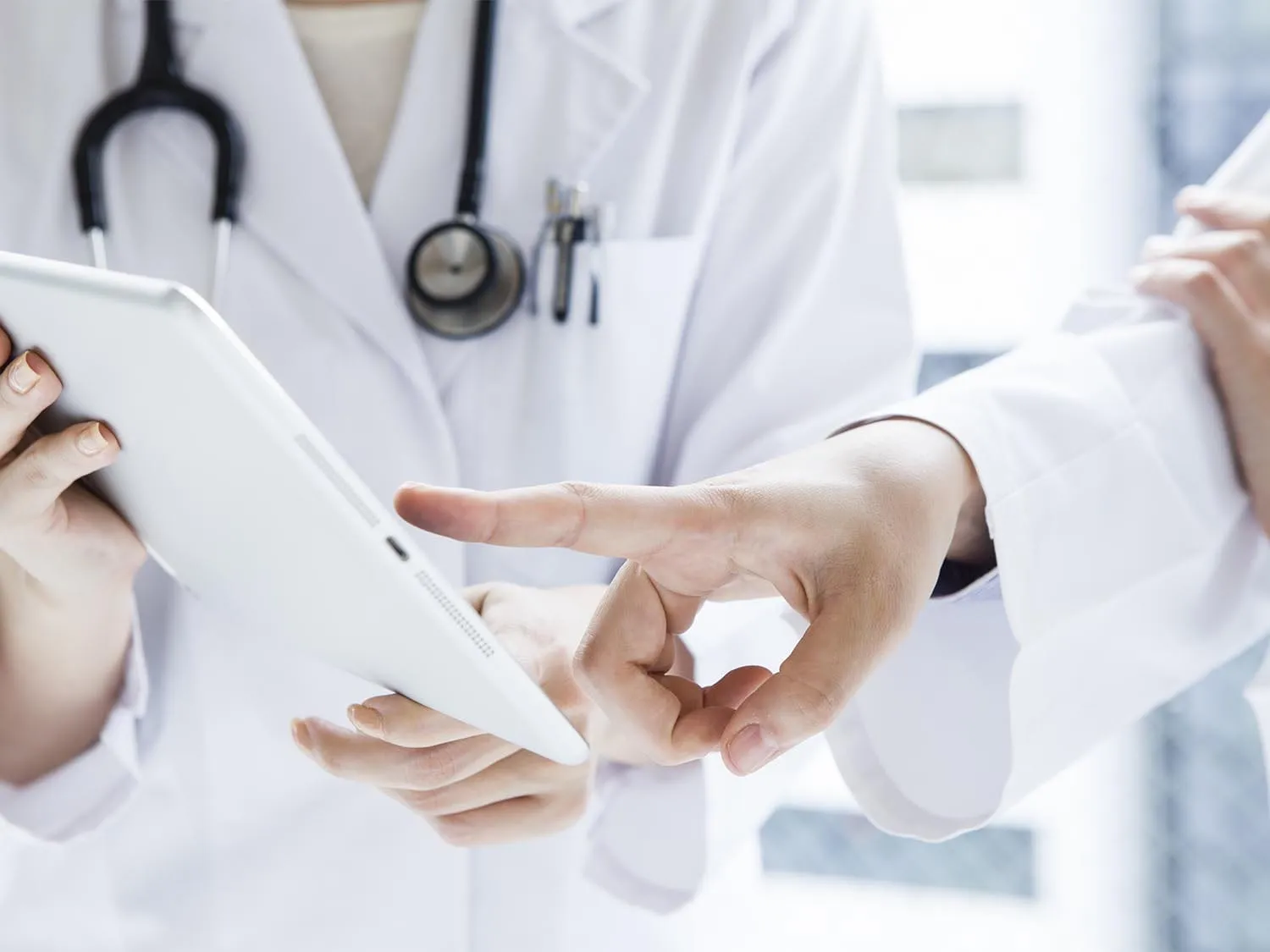 Two Physicians Looking For Medical Malpractice Insurance Quotes On A Tablet Two Physicians Looking For Medical Malpractice Insurance Quotes On A Tablet