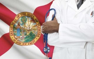 Surgeon Covered By Malpractice Insurance Standing In Front Of The Florida Flag With His Arms Crossed