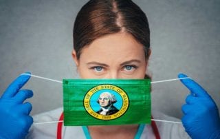 Physician Holding A Mask Over Her Face With The Washington Flag On It