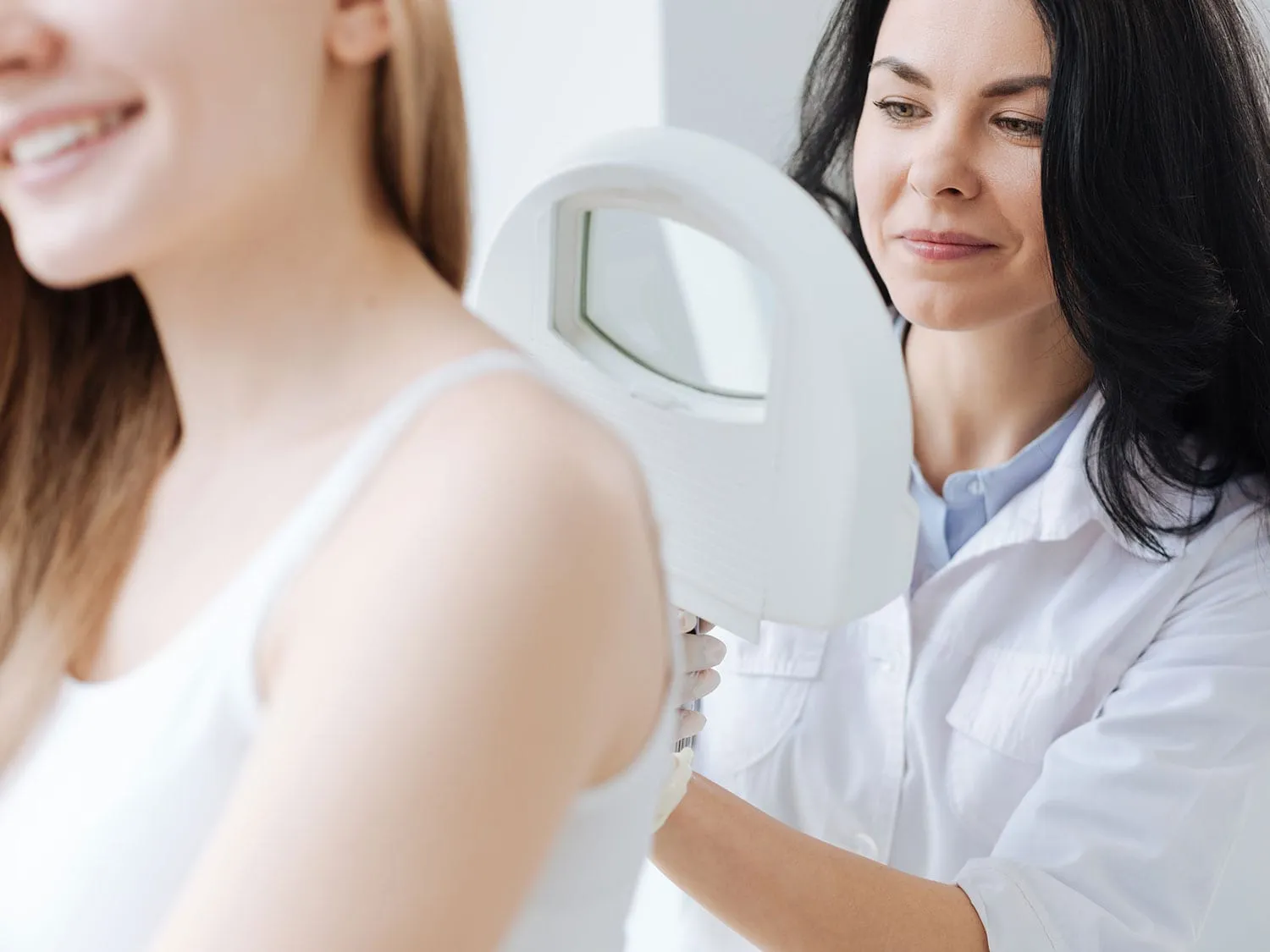 Dermatologist With Medical Malpractice Insurance Examining A Female Patients Back