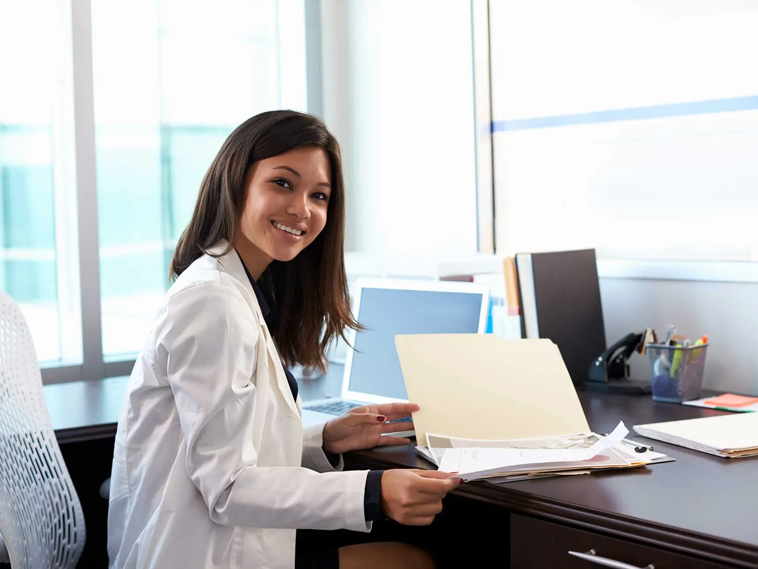 Psychiatrist-Reviewing-Medical-Malpractice-Insurance-Policies-In-Her-Office Psychiatrist Reviewing Medical Malpractice Insurance Policies In Her Office