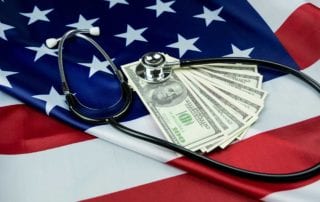 Featured Image For Why Did My Medical Malpractice Insurance Rate Increase Stethoscope And Paper Money Atop A USA Flag