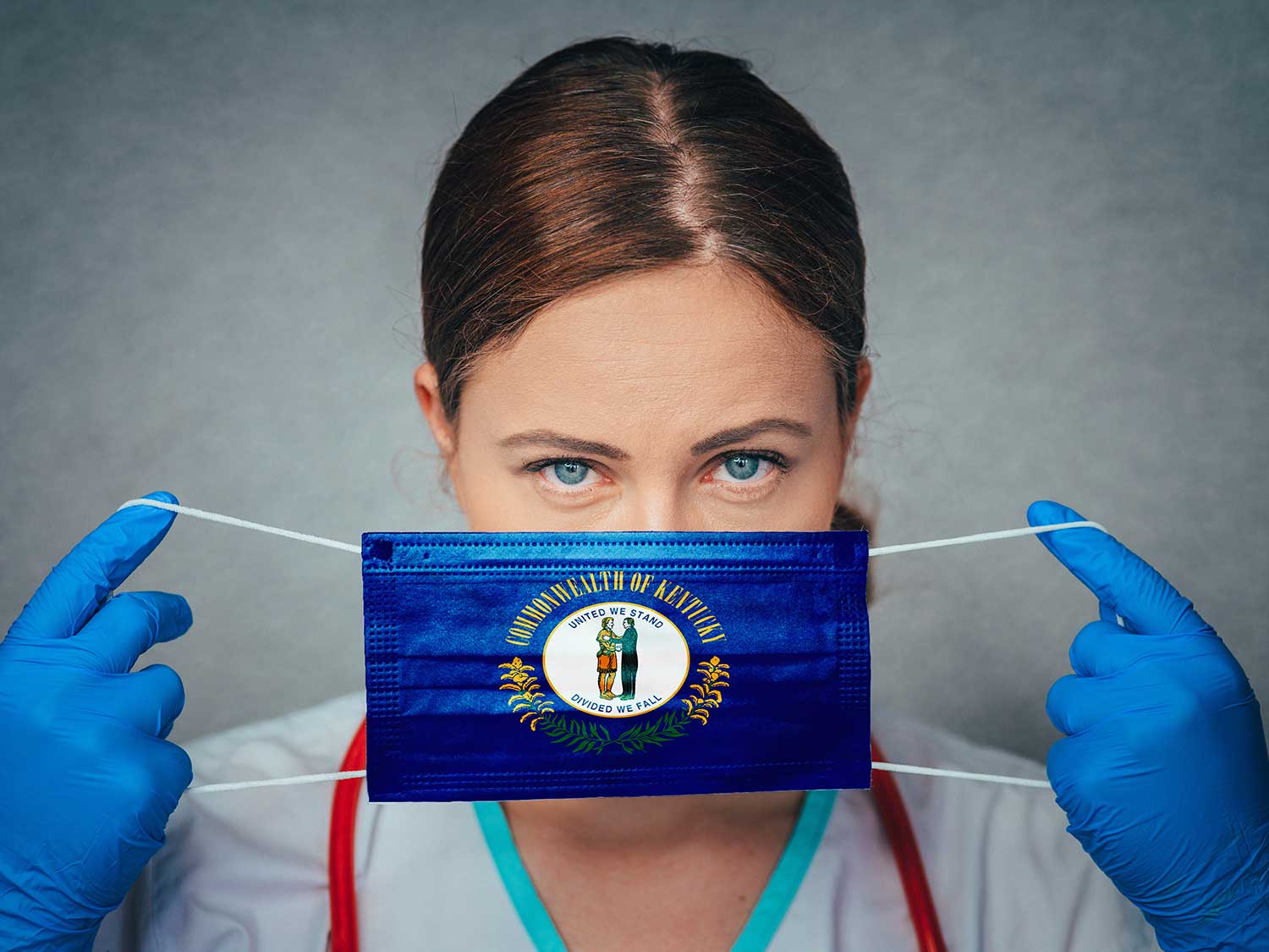 A Physician With Medical Malpractice Insurance Putting On A Surgical Mask Printed With The Kentucky State Flag