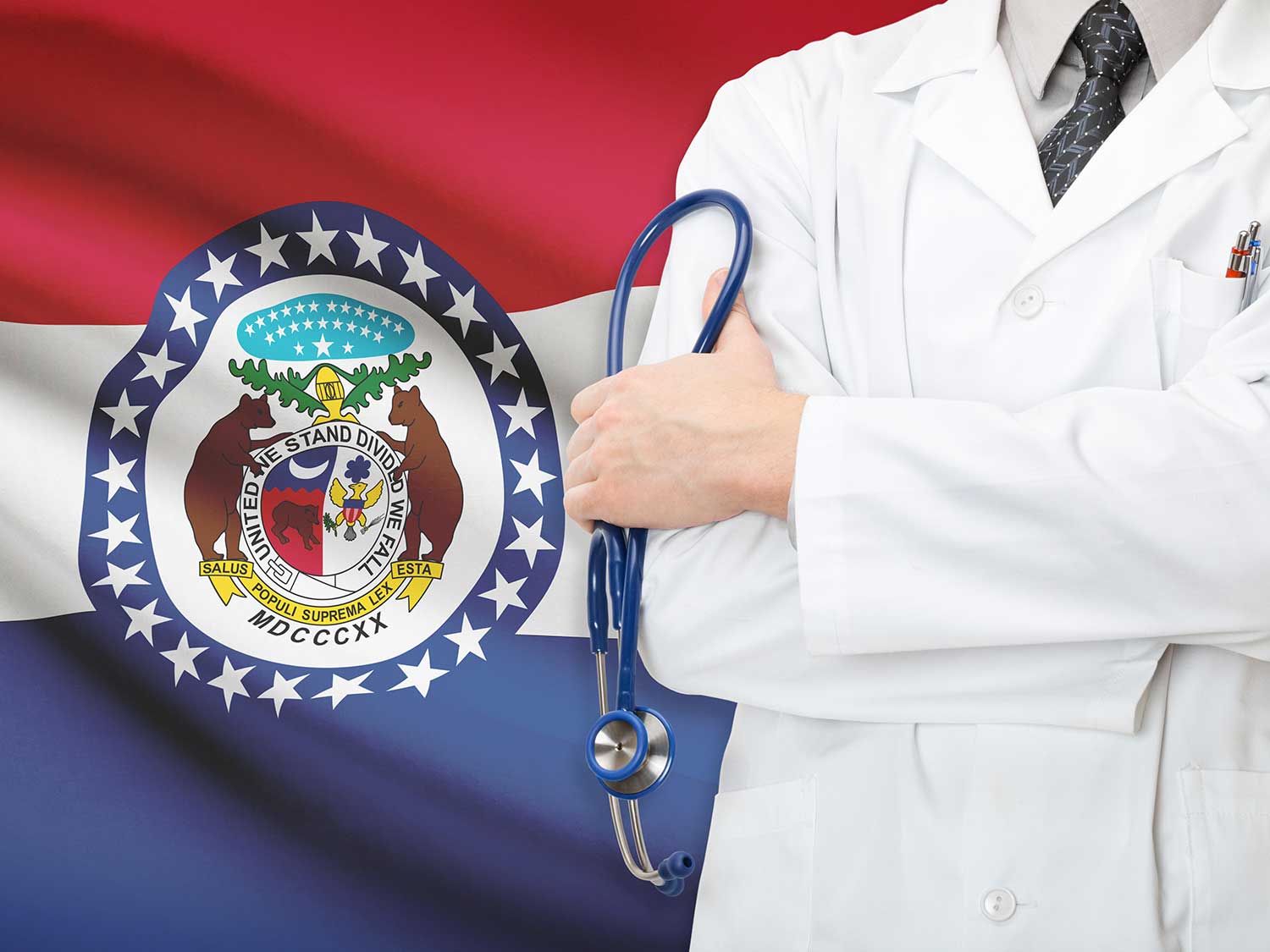 A Doctor With Medical Malpractice Insurance With His Arms Crossed In Front Of The Missouri State Flag