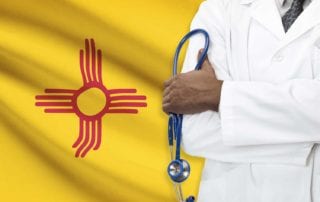 A Physician With Medical Malpractice Insurance Standing In Front Of The New Mexico State Flag