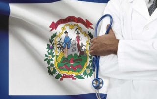 A West Virginia Doctor With Medical Malpractice Insurance Standing In Front Of The State Flag