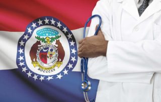 Doctor With Medical Malpractice Insurance Standing In Front Of Missouri State Flag Holding A Stethoscope